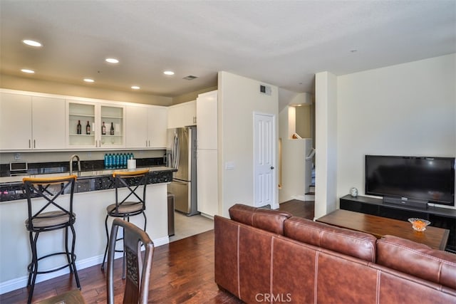 5 Arese Aisle, Irvine, CA 92606 - kitchen with stainless steel fridge with ice dispenser, open floor plan, a kitchen bar, dark countertops, and dark wood-style flooring