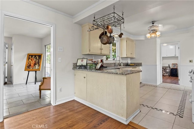 13232 Lorca Rd, La Mirada, CA 90638 - kitchen featuring cream cabinets, light tile patterned floors, plenty of natural light, a peninsula, and crown molding