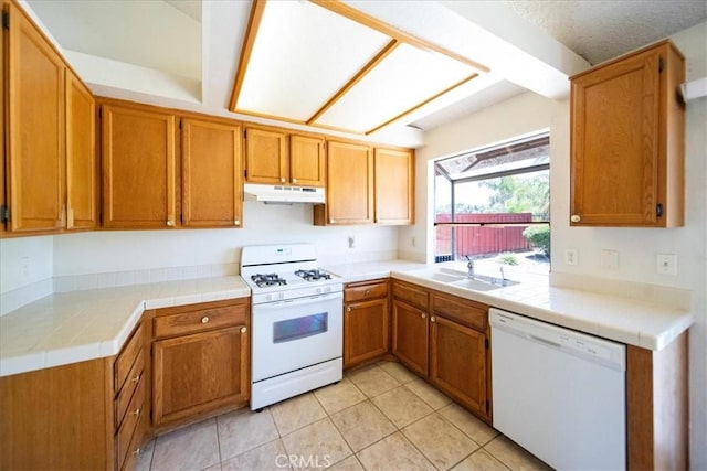 42205 Rubicon Cir, Temecula, CA 92591 - kitchen featuring white appliances, under cabinet range hood, light tile patterned floors, and brown cabinetry