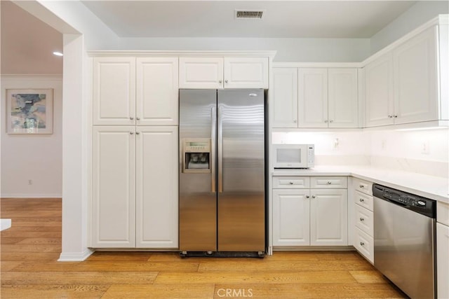 320 Bronze, Irvine, CA 92618 - kitchen with appliances with stainless steel finishes, white cabinetry, light wood-type flooring, light countertops, and recessed lighting