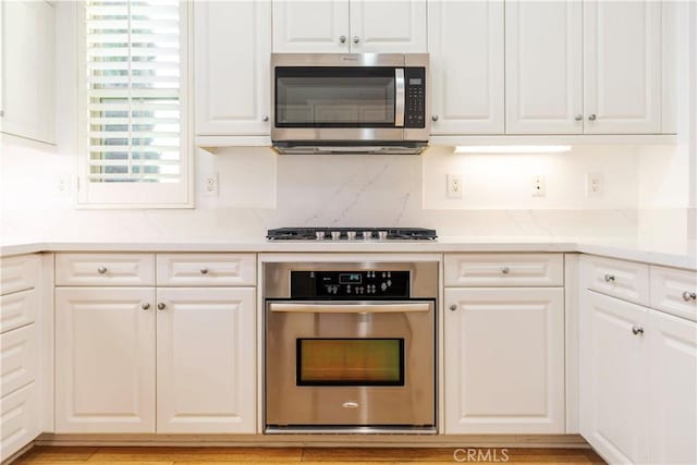 320 Bronze, Irvine, CA 92618 - kitchen featuring stainless steel appliances, white cabinetry, and backsplash