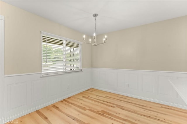 1446 Morgan Rd, San Bernardino, CA 92407 - spare room with a chandelier, wainscoting, and light wood-style flooring