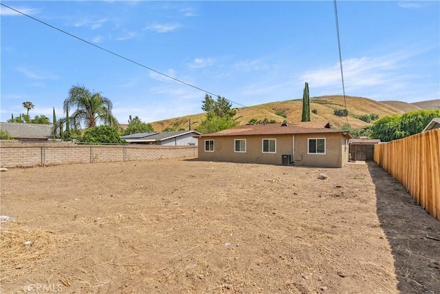 1446 Morgan Rd, San Bernardino, CA 92407 - rear view of property with stucco siding, a fenced backyard, and a mountain view
