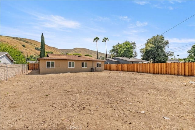 1446 Morgan Rd, San Bernardino, CA 92407 - back of house featuring a fenced backyard, stucco siding, and a mountain view
