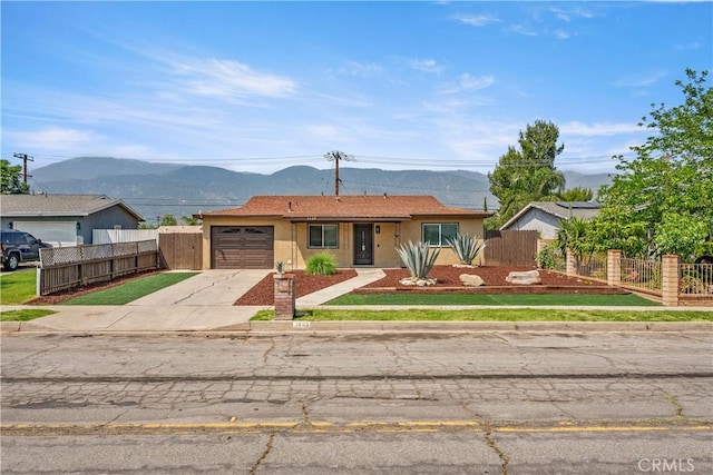 1446 Morgan Rd, San Bernardino, CA 92407 - ranch-style home featuring driveway, an attached garage, a mountain view, and stucco siding