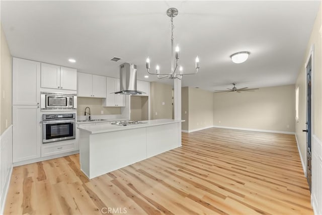 1446 Morgan Rd, San Bernardino, CA 92407 - kitchen featuring stainless steel appliances, ventilation hood, a chandelier, white cabinetry, and ceiling fan