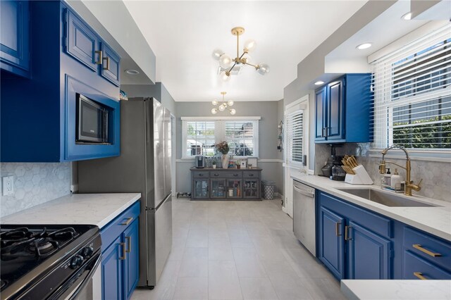 942 University Ave, Burbank, CA 91504 - kitchen with appliances with stainless steel finishes, a chandelier, blue cabinetry, backsplash, and hanging light fixtures