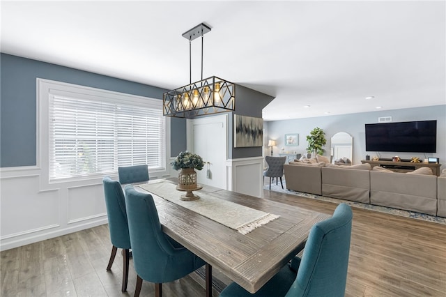 942 University Ave, Burbank, CA 91504 - dining area with light wood finished floors, arched walkways, a wainscoted wall, a decorative wall, and recessed lighting