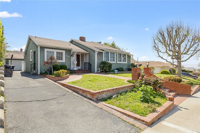 942 University Ave, Burbank, CA 91504 - view of front of home featuring stucco siding, a chimney, a front yard, and a detached garage