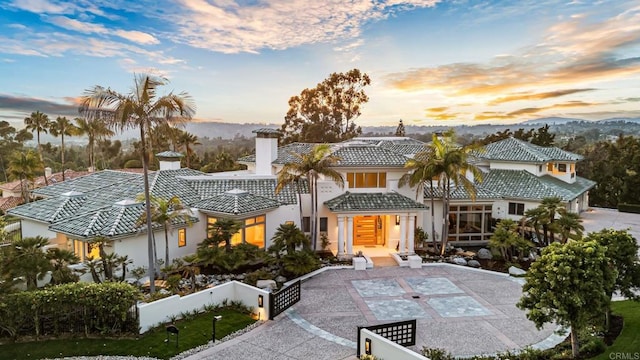 7888 Muirfield Way, Rancho Santa Fe, CA 92067 - view of front of home featuring a fenced front yard, stucco siding, a tile roof, and a mountain view