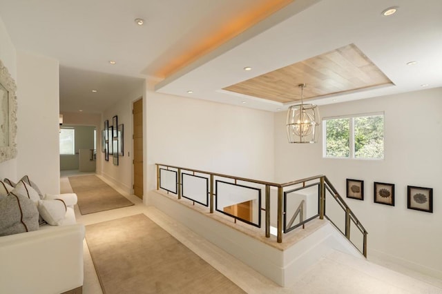 7888 Muirfield Way, Rancho Santa Fe, CA 92067 - hallway with a chandelier, a tray ceiling, recessed lighting, wooden ceiling, and an upstairs landing