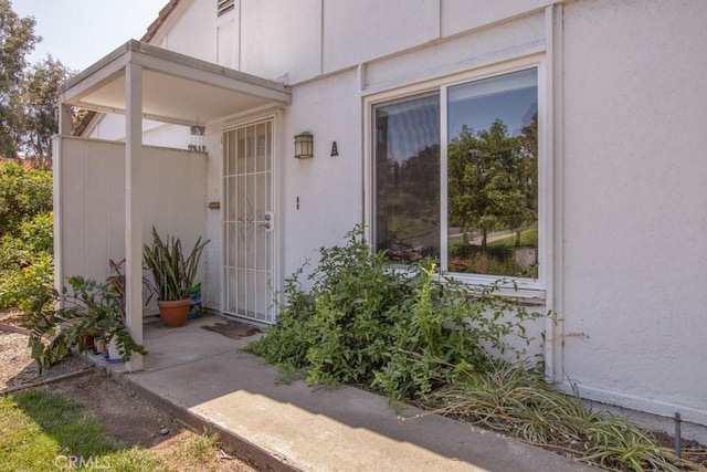 3179 Alta Vis Unit A, Laguna Woods, CA 92637 - doorway to property with stucco siding