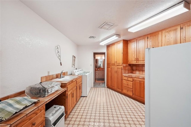 6020 Valley Sage Rd, Acton, CA 93510 - kitchen with freestanding refrigerator, washing machine and clothes dryer, light countertops, backsplash, and light flooring