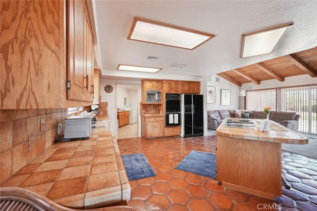 6020 Valley Sage Rd, Acton, CA 93510 - kitchen featuring black appliances, tile counters, open floor plan, light tile patterned floors, and brown cabinets
