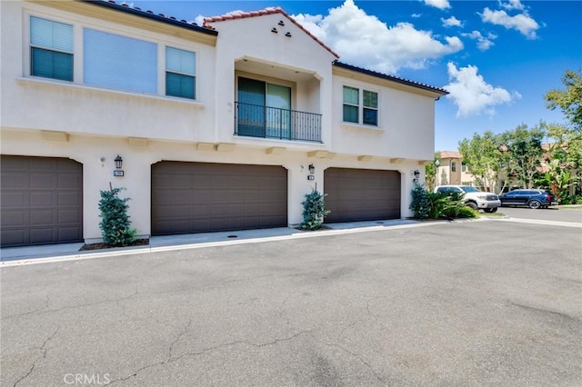16 Agave, Lake Forest, CA 92630 - view of front of property featuring stucco siding, a garage, a balcony, and a tile roof