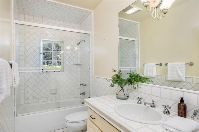 1129 Via Mirabel, Palos Verdes Estates, CA 90274 - bathroom featuring vanity, shower / bath combination with glass door, tile walls, and a wainscoted wall