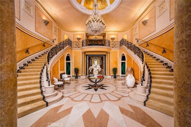 1129 Via Mirabel, Palos Verdes Estates, CA 90274 - foyer entrance featuring inlaid floor details, a chandelier, a high ceiling, stairway, and crown molding