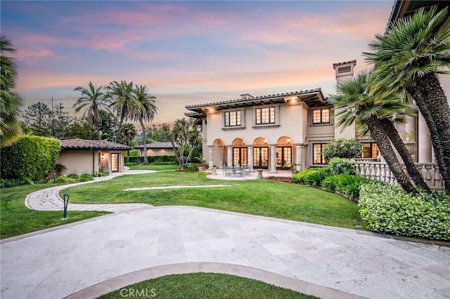 1129 Via Mirabel, Palos Verdes Estates, CA 90274 - back of property at dusk with a lawn, stucco siding, and a chimney