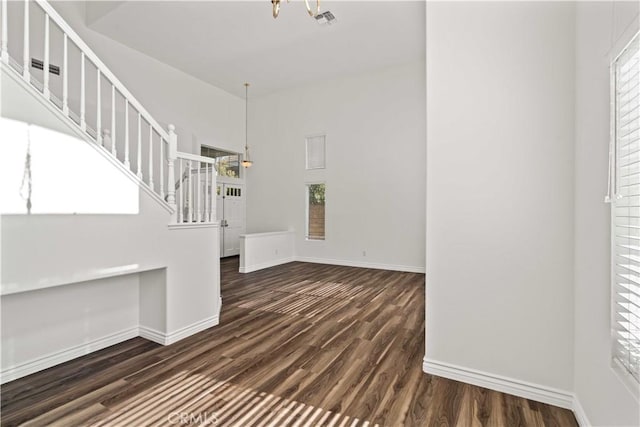 27545 Wellsley Way, Valencia, CA 91354 - unfurnished living room with a chandelier, dark wood-style flooring, stairs, and a towering ceiling