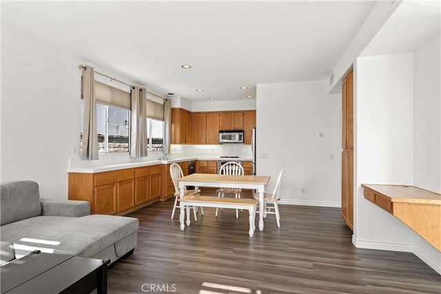 27545 Wellsley Way, Valencia, CA 91354 - kitchen with stainless steel microwave, light countertops, dark wood-style flooring, recessed lighting, and brown cabinetry