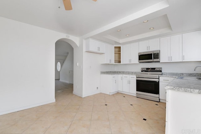 3414 Del Este Way, Oceanside, CA 92056 - kitchen featuring appliances with stainless steel finishes, a raised ceiling, light countertops, a ceiling fan, and arched walkways