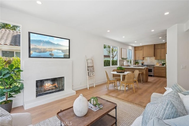 38 San Raphael, Dana Point, CA 92629 - living room featuring healthy amount of natural light, recessed lighting, light wood-type flooring, and a glass covered fireplace