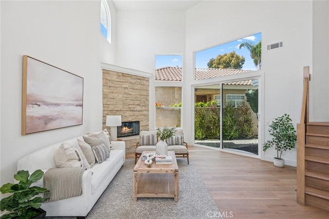 38 San Raphael, Dana Point, CA 92629 - living room with a towering ceiling, wood finished floors, a stone fireplace, and stairway
