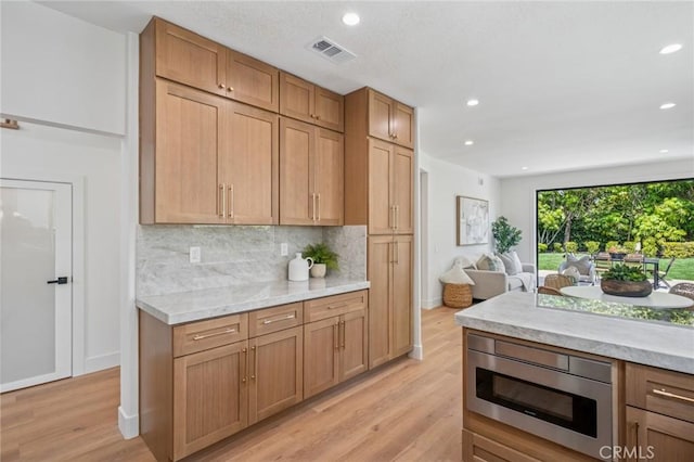 38 San Raphael, Dana Point, CA 92629 - kitchen with stainless steel microwave, light wood-style flooring, decorative backsplash, light countertops, and recessed lighting