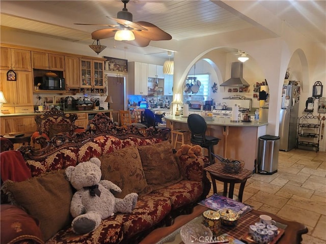 15845 La Vida Dr, Palm Springs, CA 92262 - living room featuring stone tile floors, a ceiling fan, and arched walkways