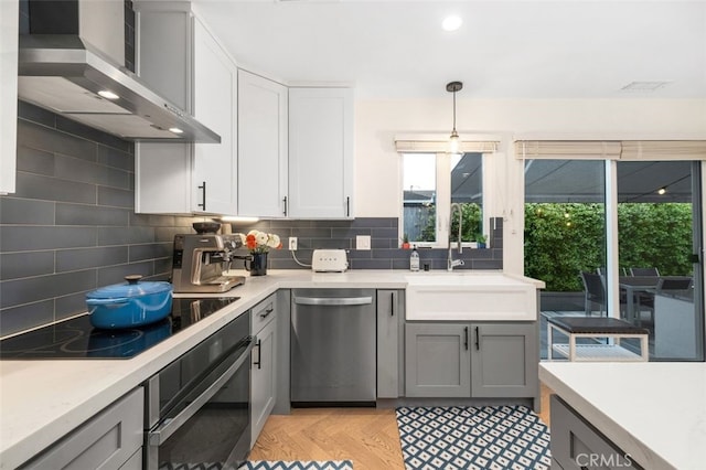 21225 Kent Ave, Torrance, CA 90503 - kitchen with appliances with stainless steel finishes, wall chimney exhaust hood, decorative backsplash, light countertops, and gray cabinets
