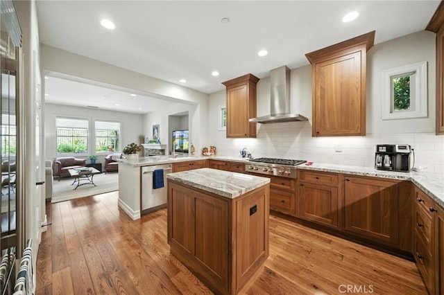 72 Shade Tree, Irvine, CA 92603 - kitchen featuring wall chimney exhaust hood, stainless steel appliances, light stone counters, a peninsula, and open floor plan