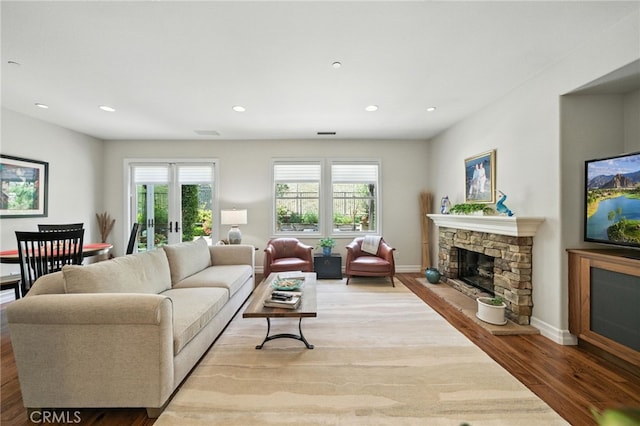 72 Shade Tree, Irvine, CA 92603 - living area with a stone fireplace, wood finished floors, recessed lighting, and french doors