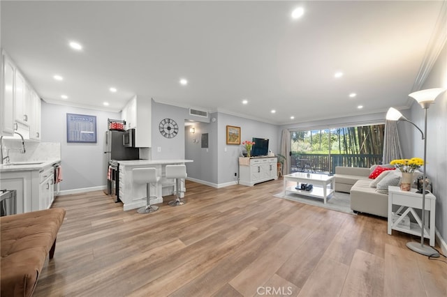 564 N Bellflower Blvd Unit 105, Long Beach, CA 90814 - living room featuring ornamental molding, recessed lighting, and light wood finished floors