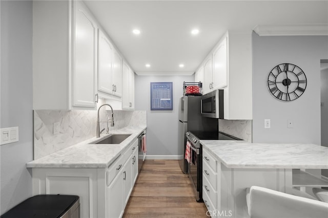 564 N Bellflower Blvd Unit 105, Long Beach, CA 90814 - kitchen with stainless steel appliances, light wood-style flooring, ornamental molding, tasteful backsplash, and white cabinetry
