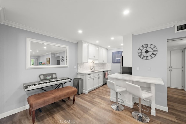 564 N Bellflower Blvd Unit 105, Long Beach, CA 90814 - kitchen featuring dishwasher, crown molding, white cabinets, light countertops, and wood finished floors