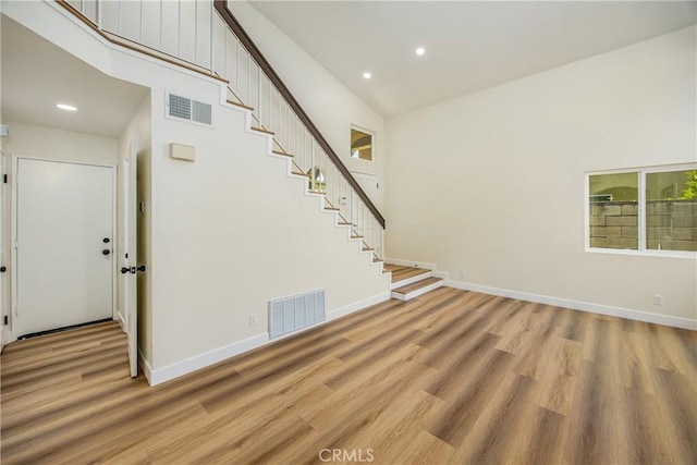 11142 Malone St, Rancho Cucamonga, CA 91701 - unfurnished living room with stairway, light wood finished floors, recessed lighting, and a high ceiling