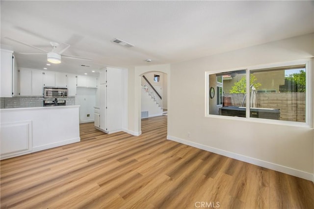 11142 Malone St, Rancho Cucamonga, CA 91701 - unfurnished living room with light wood-style flooring, arched walkways, a ceiling fan, and stairway