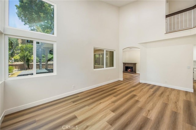 11142 Malone St, Rancho Cucamonga, CA 91701 - unfurnished living room with a towering ceiling, a fireplace, and wood finished floors