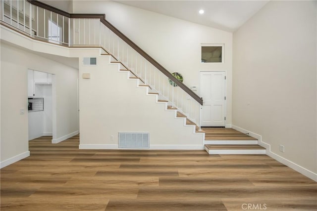 11142 Malone St, Rancho Cucamonga, CA 91701 - staircase featuring high vaulted ceiling, wood finished floors, and recessed lighting
