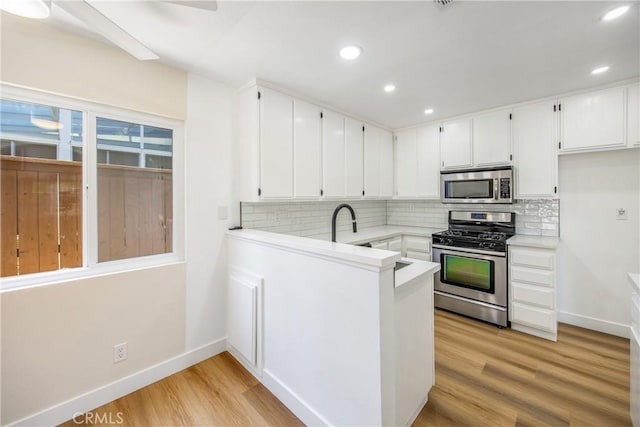 11142 Malone St, Rancho Cucamonga, CA 91701 - kitchen featuring appliances with stainless steel finishes, light wood finished floors, backsplash, white cabinetry, and recessed lighting