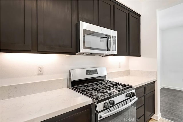 13219 Shaw Ln, Sylmar, CA 91342 - kitchen with appliances with stainless steel finishes, light stone countertops, light wood-style flooring, and dark brown cabinetry