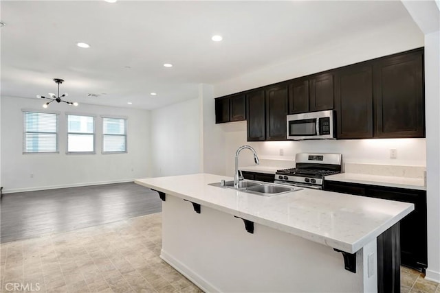 13219 Shaw Ln, Sylmar, CA 91342 - kitchen featuring appliances with stainless steel finishes, a kitchen breakfast bar, a chandelier, an island with sink, and recessed lighting