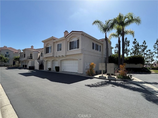28741 La Triana, Laguna Niguel, CA 92677 - view of front of house featuring a chimney, stucco siding, a garage, a tiled roof, and a residential view