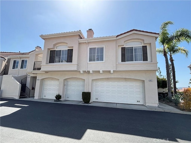 28741 La Triana, Laguna Niguel, CA 92677 - view of front of property with stucco siding, a chimney, an attached garage, and a tiled roof