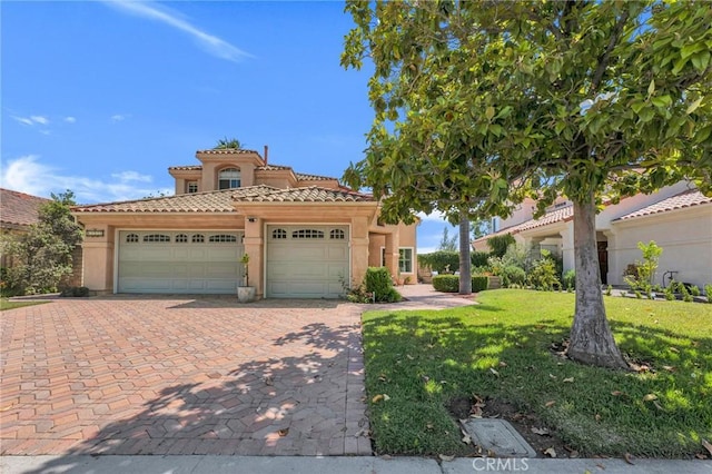 15736 Milne Cir, Moorpark, CA 93021 - mediterranean / spanish house featuring an attached garage, a tiled roof, stucco siding, decorative driveway, and a front yard