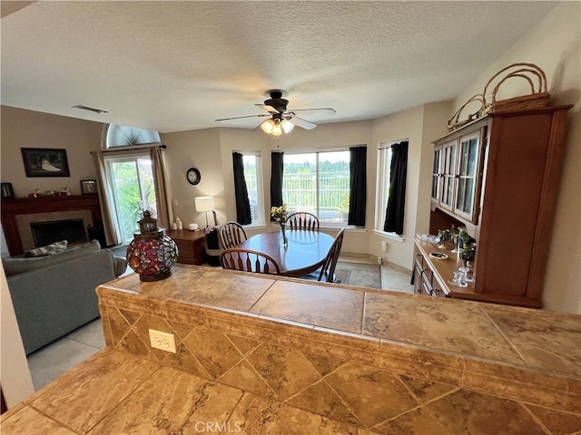 27347 Sahara Pl, Laguna Niguel, CA 92677 - dining room with ceiling fan, a fireplace, and a textured ceiling