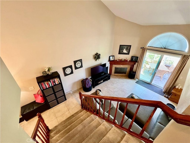 27347 Sahara Pl, Laguna Niguel, CA 92677 - staircase featuring tile patterned floors, a glass covered fireplace, and high vaulted ceiling
