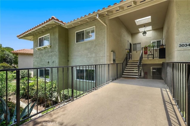 3034 Via Vis Unit A, Laguna Woods, CA 92637 - view of exterior entry with stucco siding, a tiled roof, and a balcony