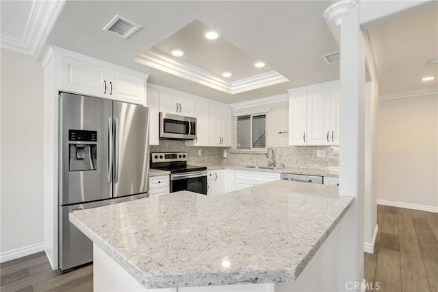 3034 Via Vis Unit A, Laguna Woods, CA 92637 - kitchen with appliances with stainless steel finishes, ornamental molding, a raised ceiling, backsplash, and dark wood-style floors