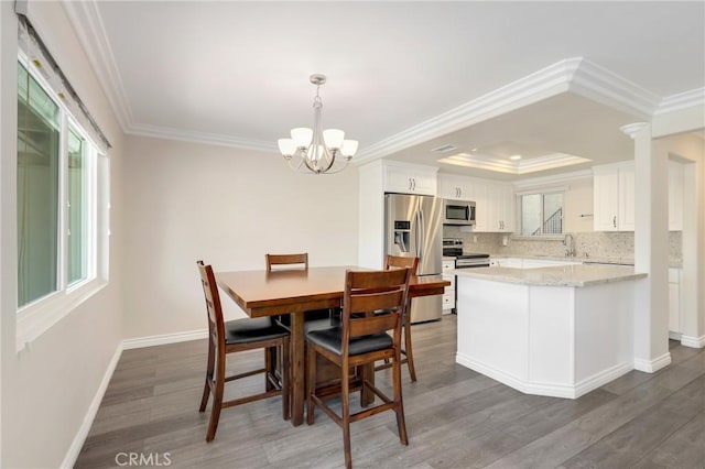 3034 Via Vis Unit A, Laguna Woods, CA 92637 - dining space with a chandelier, wood finished floors, crown molding, and a tray ceiling